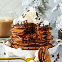 fluffy hot cocoa pancakes on a plate with marshmallows