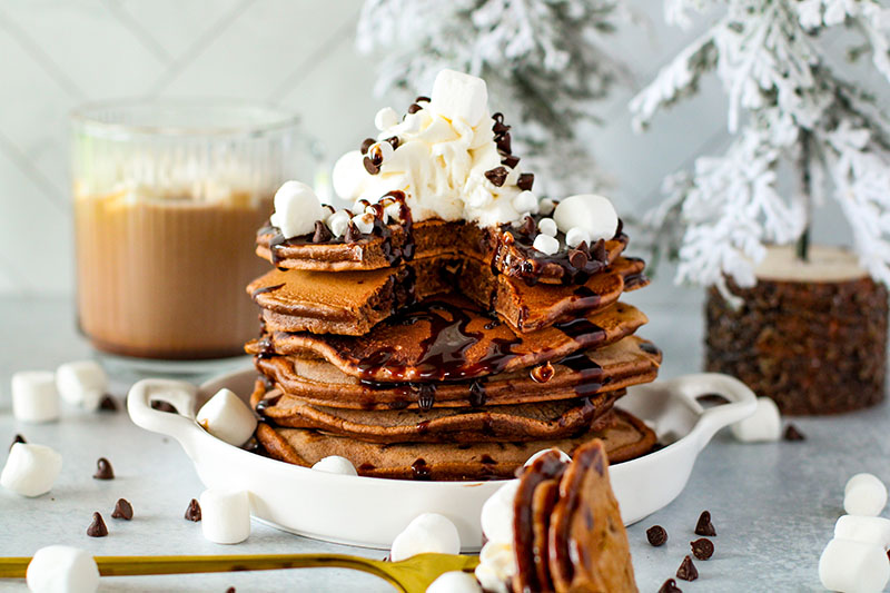 fluffy hot cocoa pancakes on a plate with marshmallows