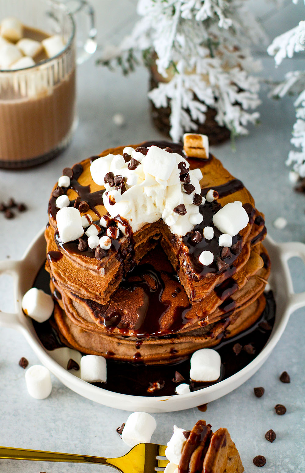 fluffy hot cocoa pancakes on a plate with marshmallows 