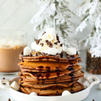 fluffy hot cocoa pancakes on a plate with marshmallows