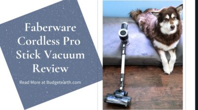 Ivi the red Alaskan malamute sitting next to and looking curiously at the Faberware Cordless Pro Stick Vacuum