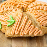 up close picture of picture of carrot cake scones with icing on a board